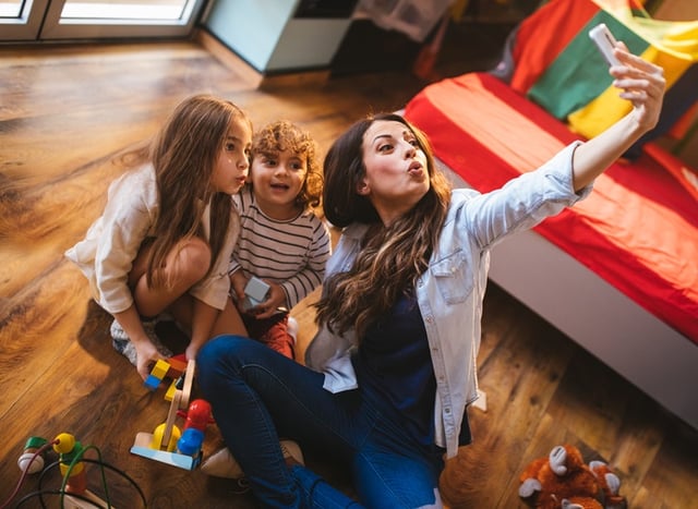 Baby sitter taking selfie with kids