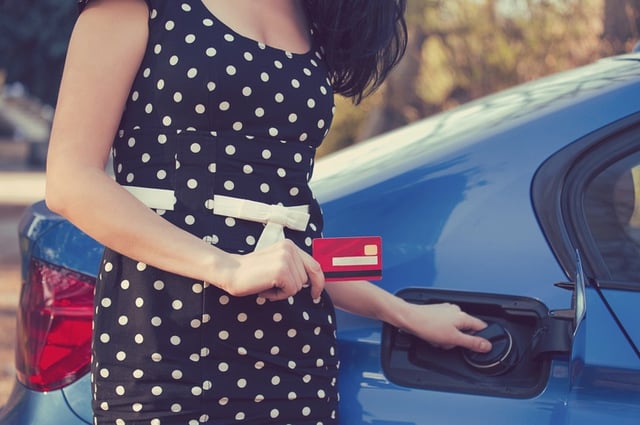 Freelance business woman filling car with gas.jpg