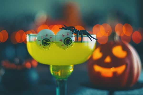 yellow festive Halloween drink with eyeballs and spider for decoration 