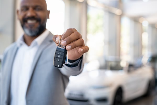 african american man holding keys in florida car dealership