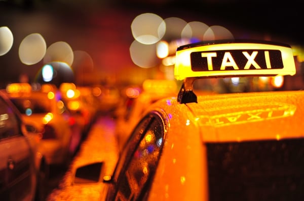 yellow taxi lined up in city wet from rain 