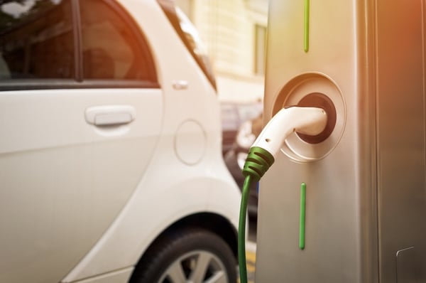 white electric car charging on the street