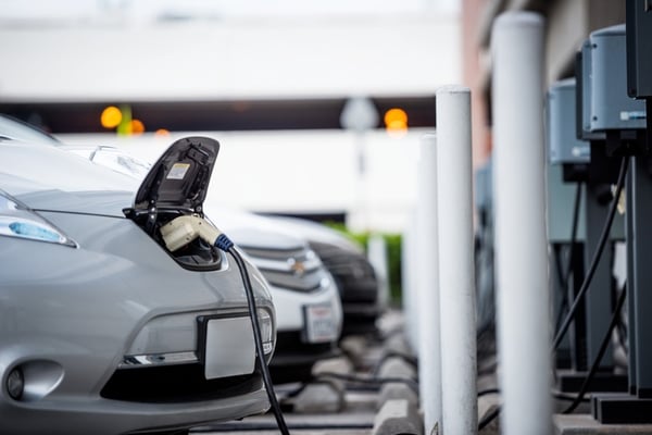 different brands of electric vehicles charging on the street