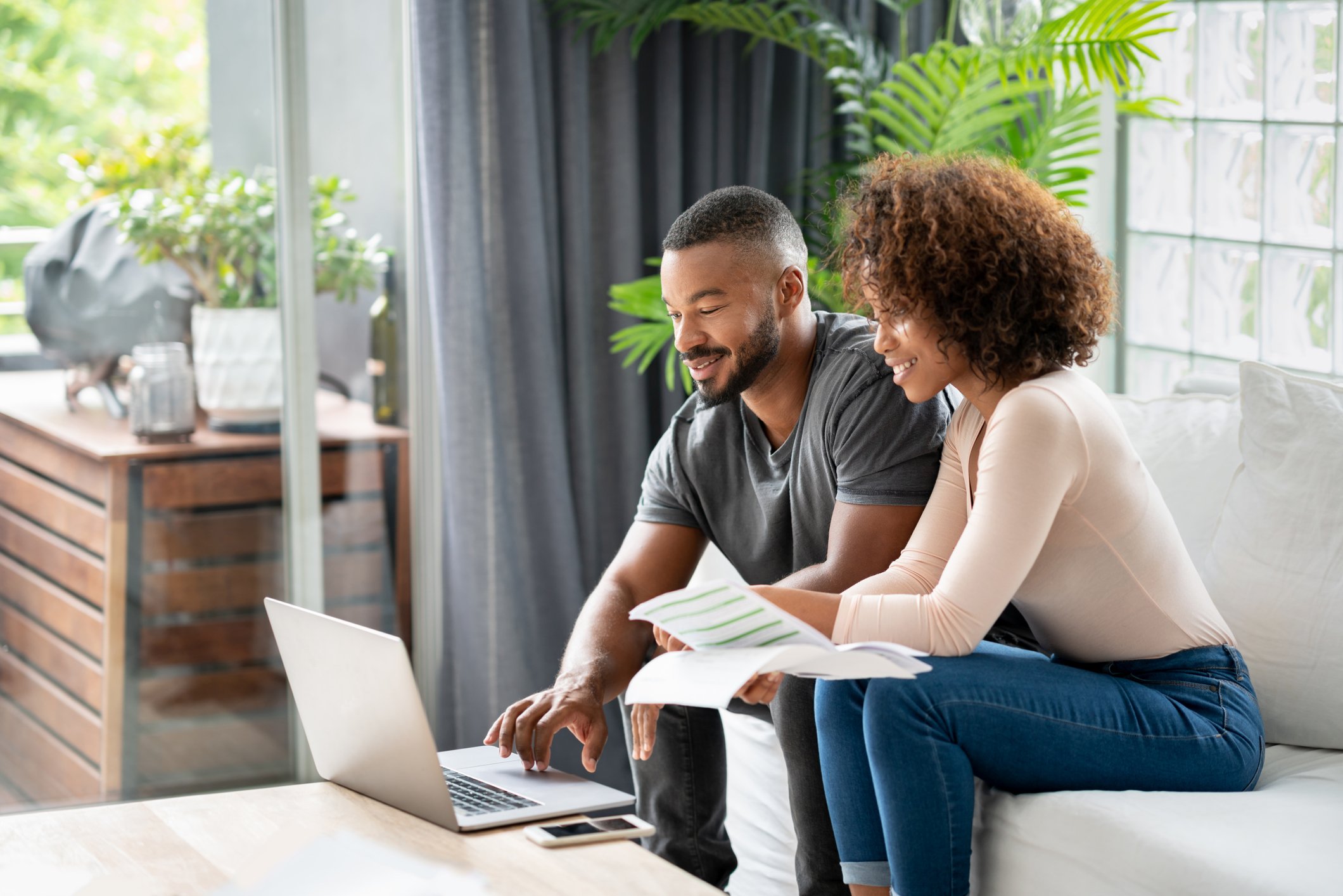 African American couple on couch discussing finances