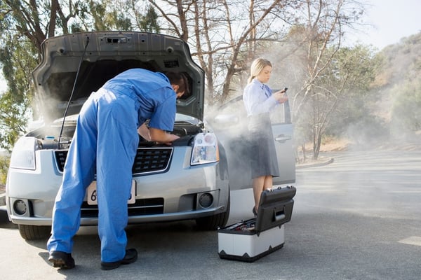 car broken down on side of engine while mechanic looks at engine