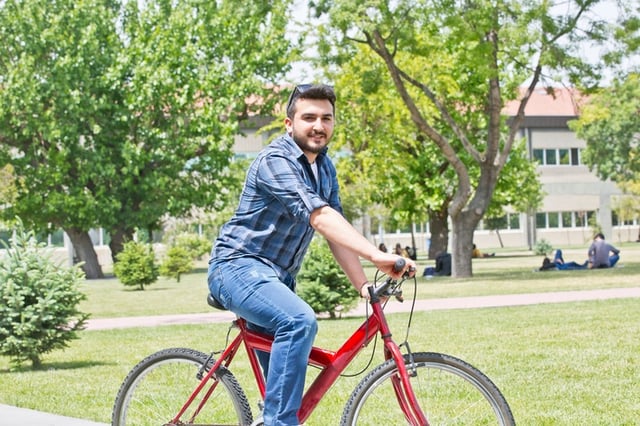 college kid riding bike around campus
