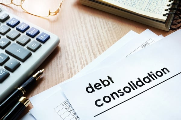 debt consolidation paper with computer and notebook