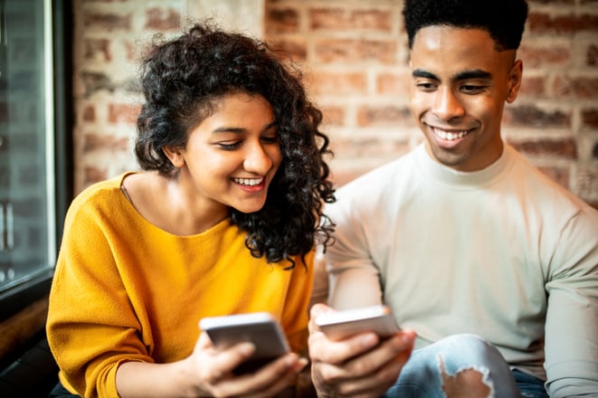 friends at coffee shop using cell phones to send cash