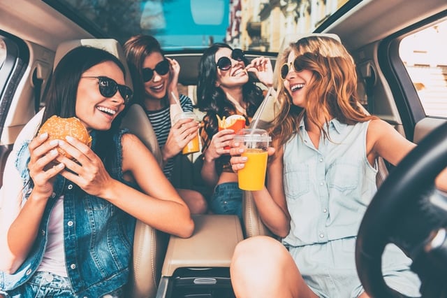 friends enjoying snacks on road trip