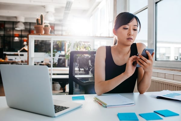 girl turning off alarms on her phone while at work