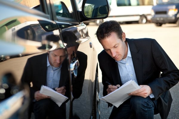 man inspecting used vehicle