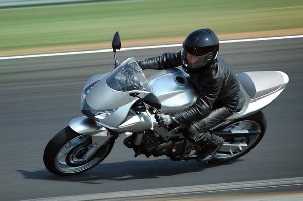 rider going fast on silver sporty motorcycle