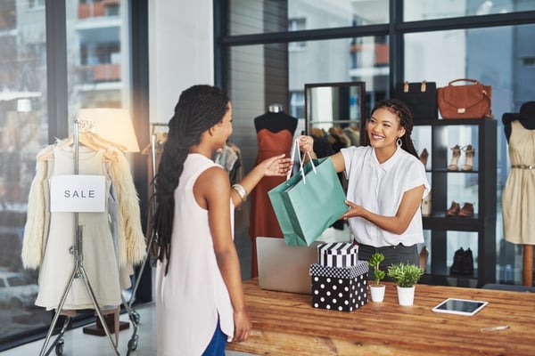 salesperson handing items over to a girl paying