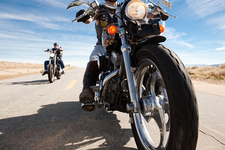 two men riding motorcycle on open road
