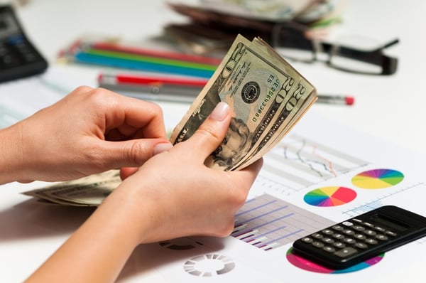 woman counting money to pay off debt