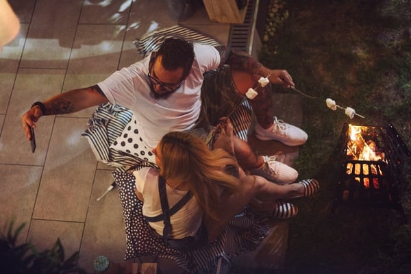 young couple taking selfie in front of backyard firepit