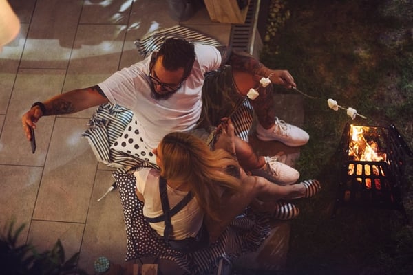 young couple taking selfie in front of backyard firepit