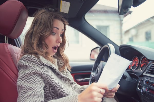 young girl reading fine print in car suprised