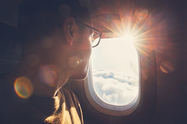 young guy looking out the window on an air plane