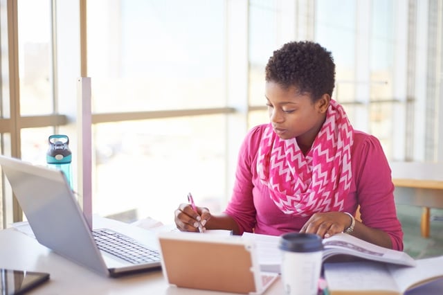 young woman in pink doing research