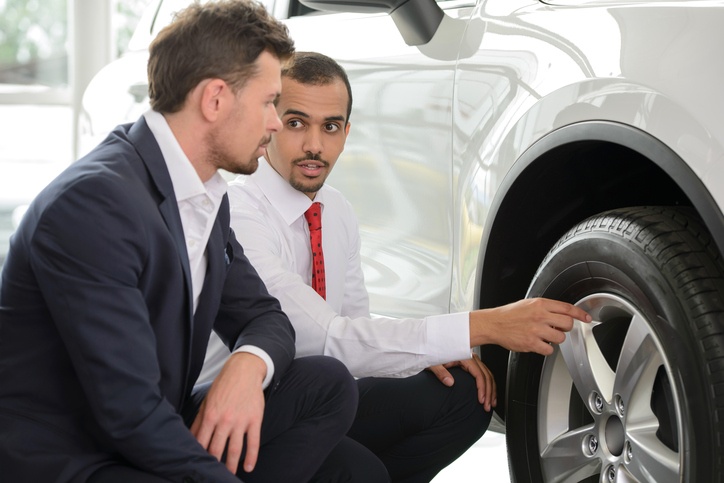 Man looking at tires on car