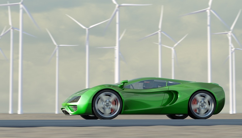 green sportscar speeding past turbines